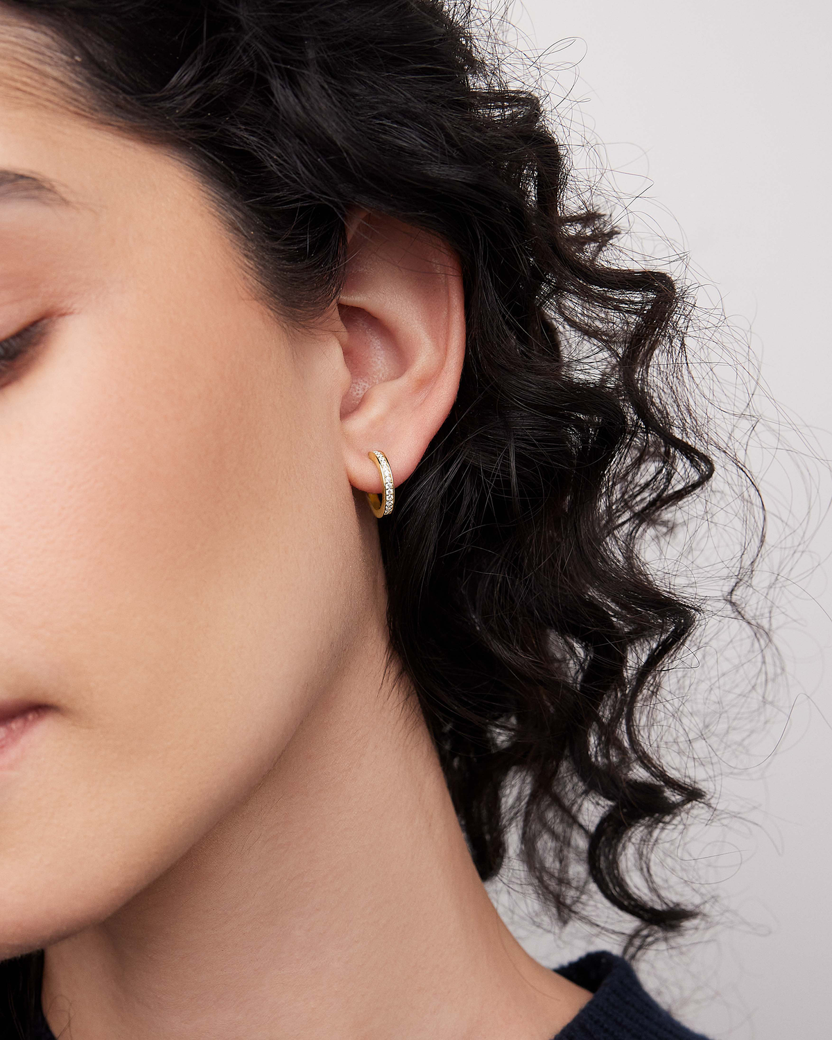 18k Small Huggie with Pavé Diamonds 18K gold earring - close-up detail | diamond huggie earrings